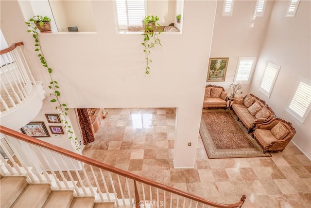 staircase featuring a wealth of natural light and a towering ceiling