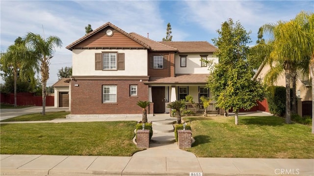 view of front of house featuring a front yard, a garage, and covered porch