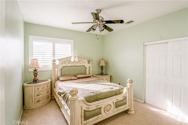 bedroom featuring a closet, light colored carpet, and ceiling fan