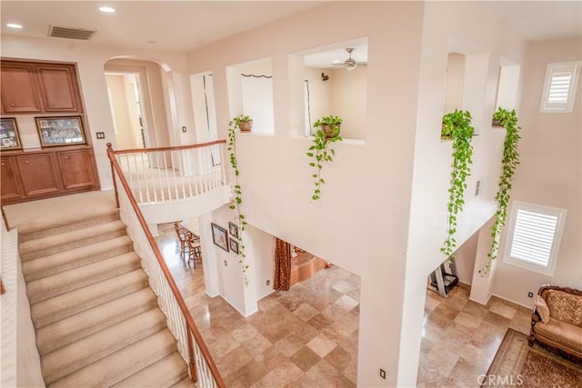 staircase featuring ceiling fan and a wealth of natural light