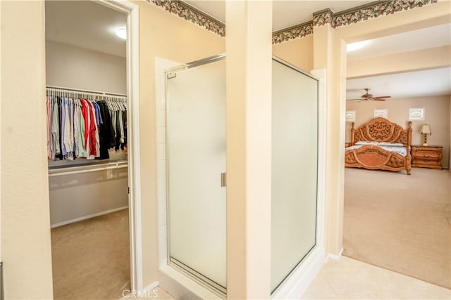 bathroom featuring ceiling fan and a shower with door