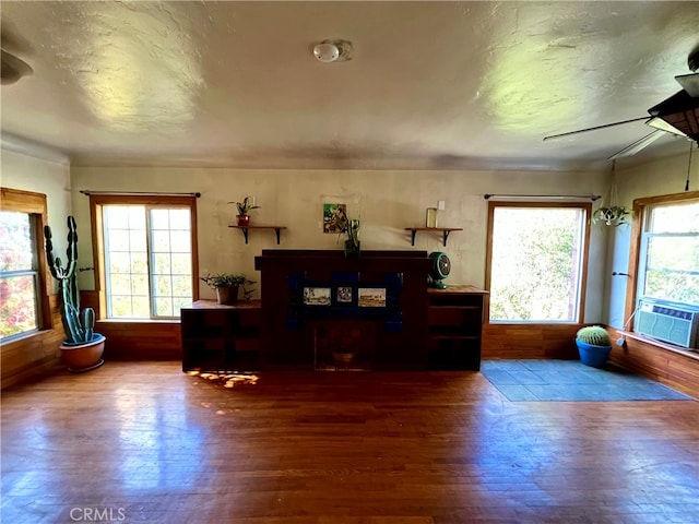 interior space with hardwood / wood-style flooring, a wealth of natural light, ceiling fan, and cooling unit