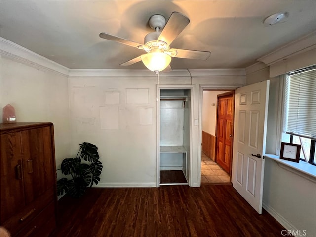 unfurnished bedroom featuring dark wood-type flooring, ornamental molding, and ceiling fan