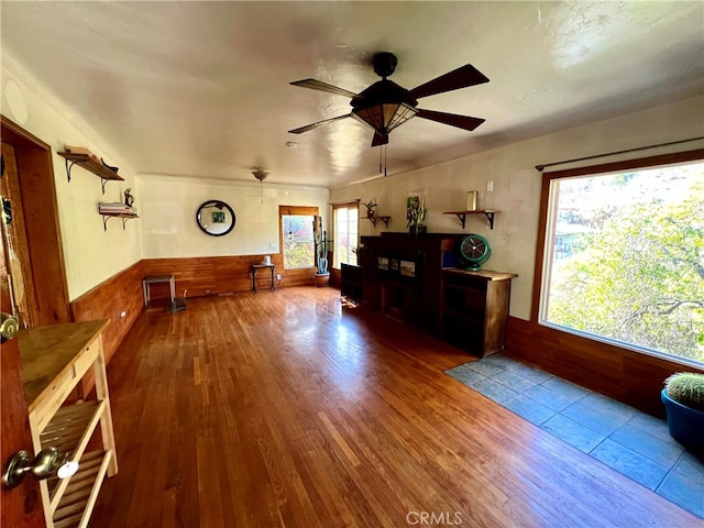 interior space featuring ceiling fan, hardwood / wood-style floors, and wooden walls