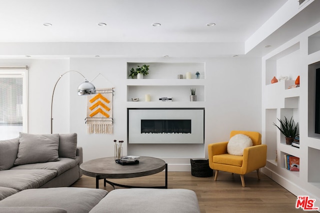 living room featuring hardwood / wood-style flooring and built in shelves