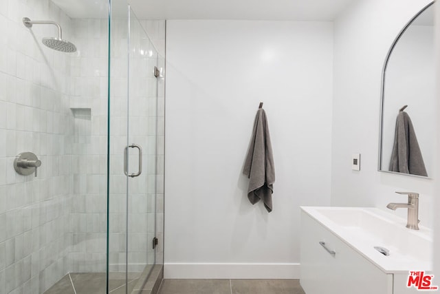 bathroom with vanity, tile patterned floors, and a shower with door