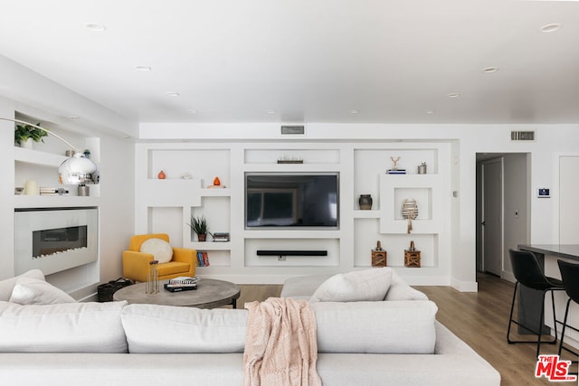 living room featuring hardwood / wood-style floors and built in features