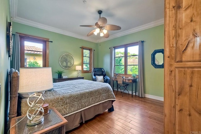 bedroom with hardwood / wood-style flooring, ceiling fan, and crown molding