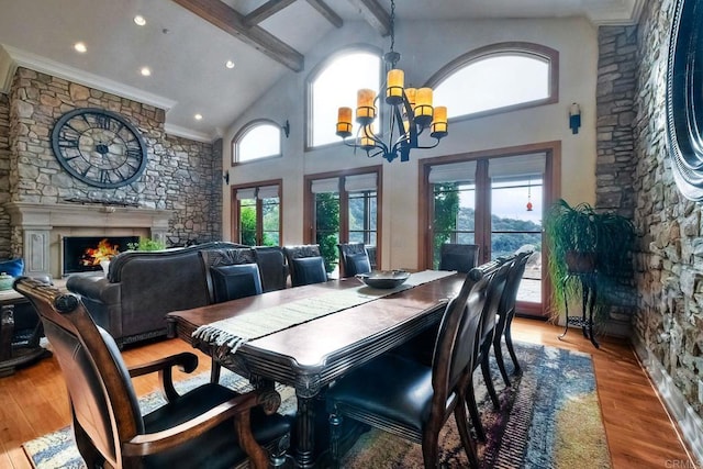 dining space featuring hardwood / wood-style floors, an inviting chandelier, high vaulted ceiling, and a healthy amount of sunlight