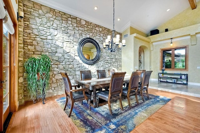 dining area with high vaulted ceiling, crown molding, hardwood / wood-style flooring, a notable chandelier, and beam ceiling