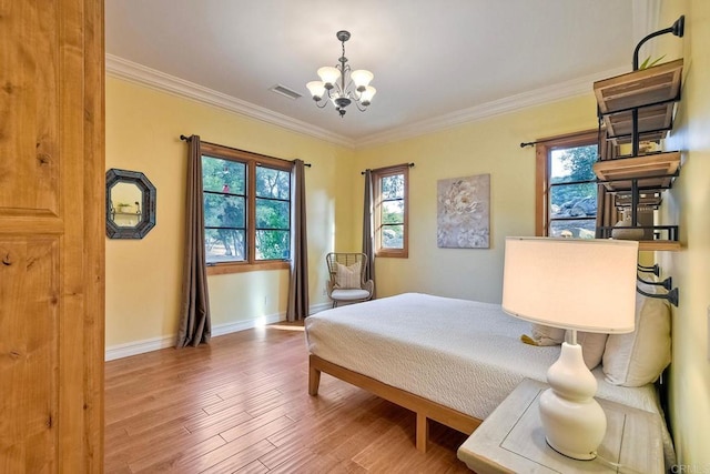 bedroom featuring multiple windows, hardwood / wood-style floors, and ornamental molding