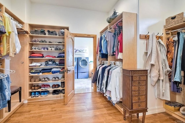 spacious closet featuring washer / dryer and light hardwood / wood-style flooring