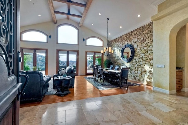 interior space with light hardwood / wood-style floors, beam ceiling, high vaulted ceiling, and a chandelier