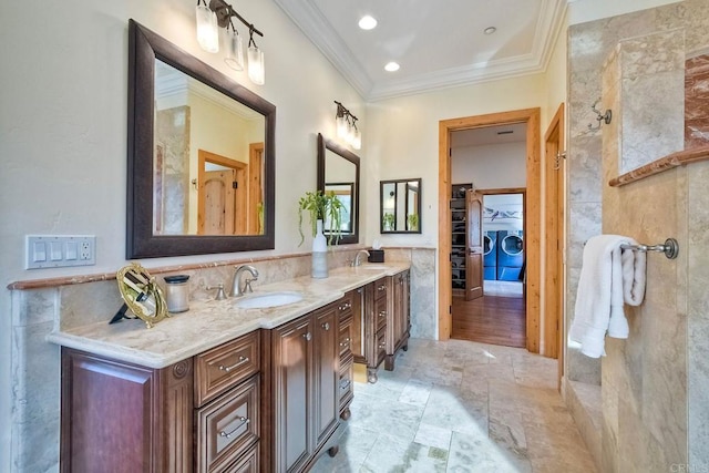 bathroom with washer and dryer, vanity, tile walls, and ornamental molding