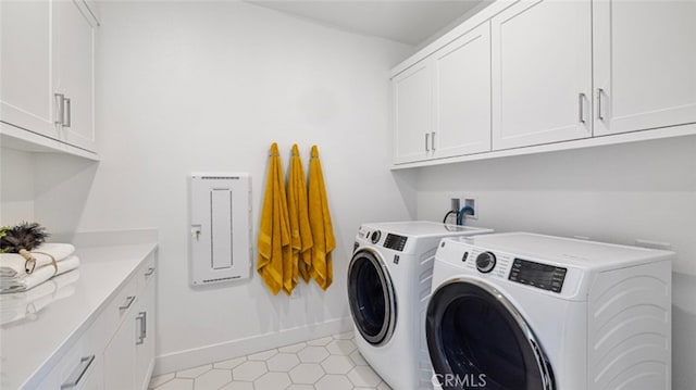 clothes washing area with washer and dryer and cabinets