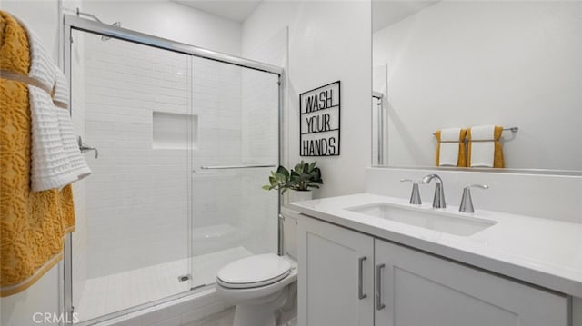 bathroom featuring an enclosed shower, vanity, and toilet