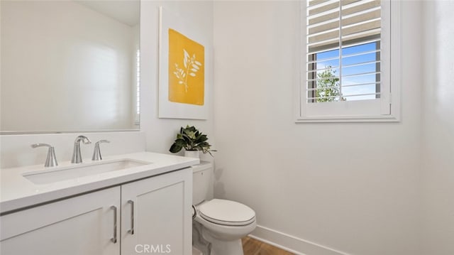 bathroom with hardwood / wood-style flooring, vanity, and toilet