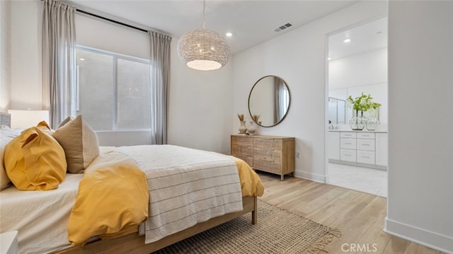 bedroom with connected bathroom and hardwood / wood-style floors