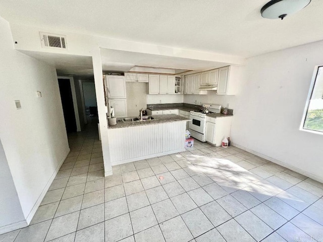 kitchen featuring white cabinets, sink, white gas range, kitchen peninsula, and light tile patterned floors