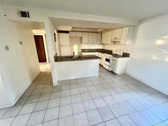 kitchen featuring white cabinetry, white gas range, light tile patterned flooring, and sink