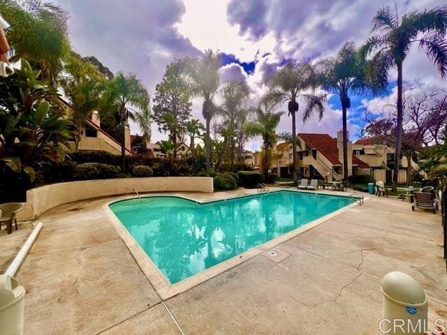 pool at dusk featuring a patio