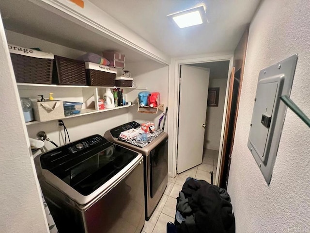 washroom featuring washer and dryer, light tile patterned floors, and electric panel