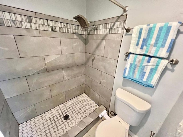 bathroom featuring toilet and tiled shower