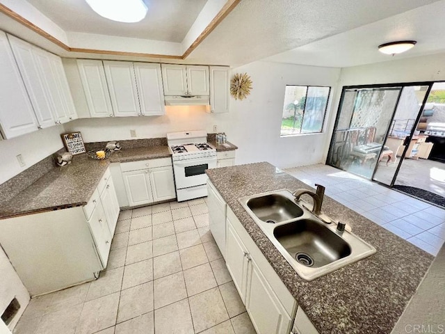 kitchen featuring white gas range, sink, and white cabinets