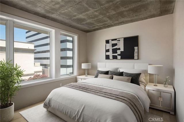 bedroom featuring multiple windows and hardwood / wood-style floors