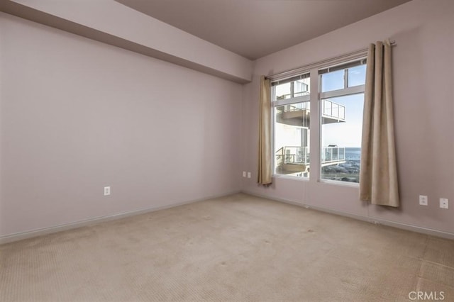 spare room featuring light colored carpet