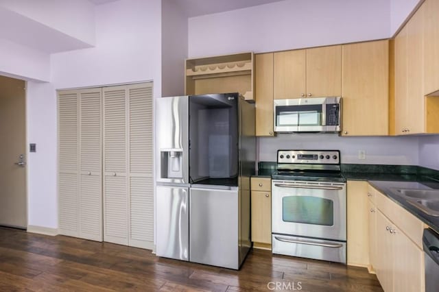 kitchen with dark hardwood / wood-style floors, stainless steel appliances, light brown cabinets, and sink