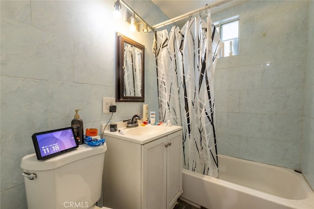 full bathroom featuring vanity, toilet, shower / bath combo with shower curtain, and tile walls