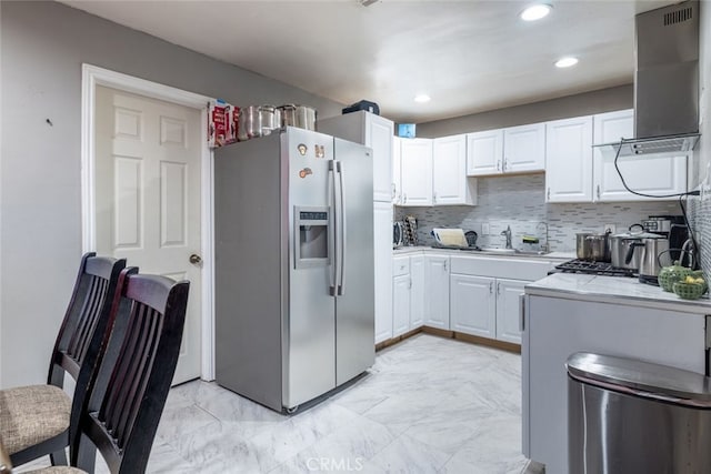 kitchen with white cabinetry, decorative backsplash, stainless steel fridge with ice dispenser, and exhaust hood