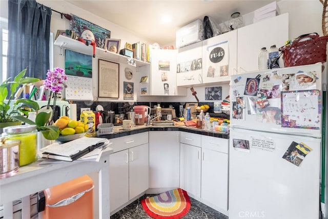 kitchen featuring white cabinets and white refrigerator