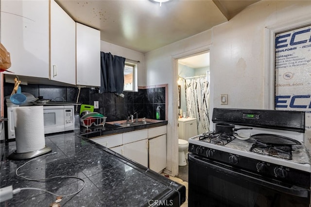 kitchen featuring decorative backsplash, sink, white cabinets, and white appliances