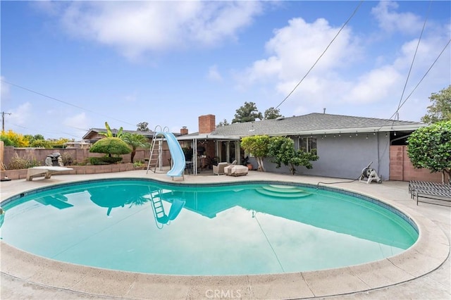 view of swimming pool featuring a patio and a water slide