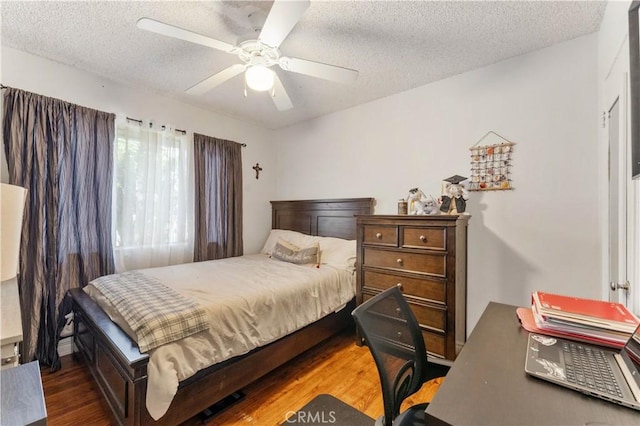 bedroom featuring a textured ceiling, dark hardwood / wood-style floors, and ceiling fan