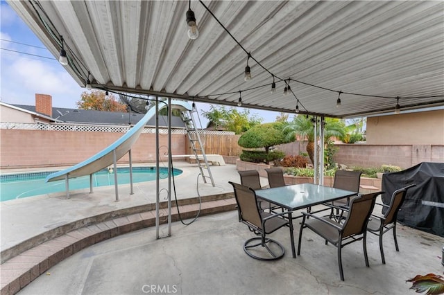 view of patio / terrace with a fenced in pool and a grill