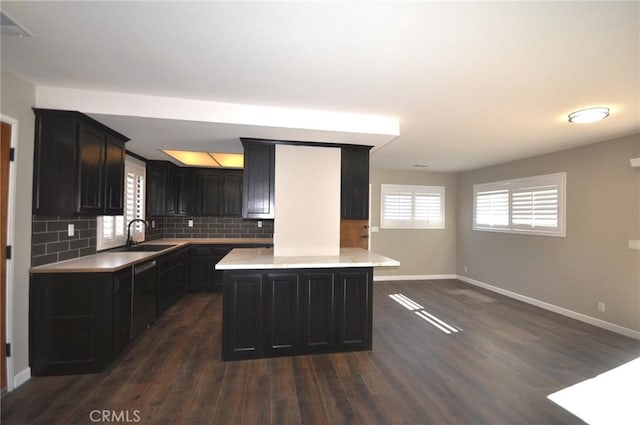 kitchen featuring a center island, sink, backsplash, and dark hardwood / wood-style flooring