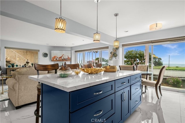 kitchen with a center island, light stone countertops, blue cabinets, and hanging light fixtures