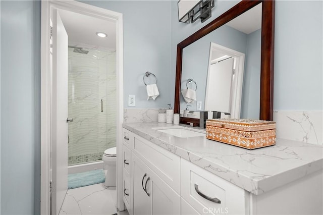 bathroom featuring vanity, toilet, and an enclosed shower