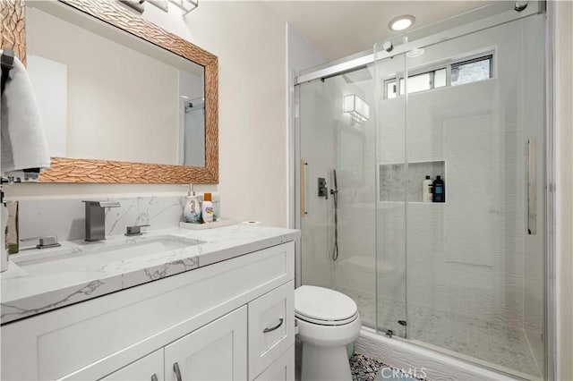 bathroom with vanity, toilet, decorative backsplash, and walk in shower