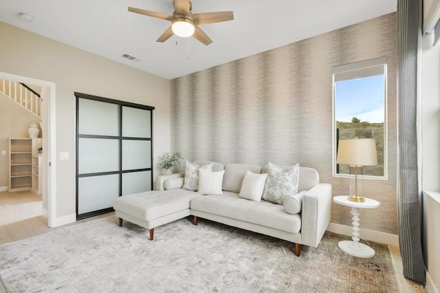 living room with light hardwood / wood-style flooring and ceiling fan