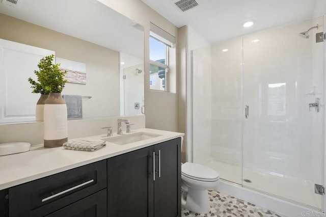 bathroom with tile patterned flooring, vanity, toilet, and a shower with shower door