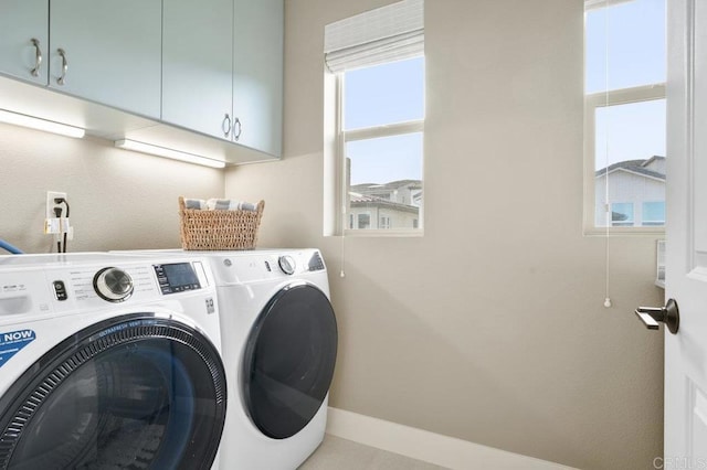 clothes washing area featuring cabinets and washing machine and dryer