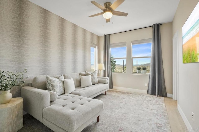 living area featuring light wood-type flooring and ceiling fan