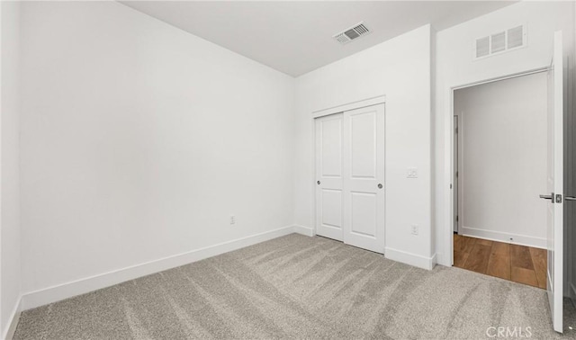 unfurnished bedroom featuring carpet floors, baseboards, and a closet