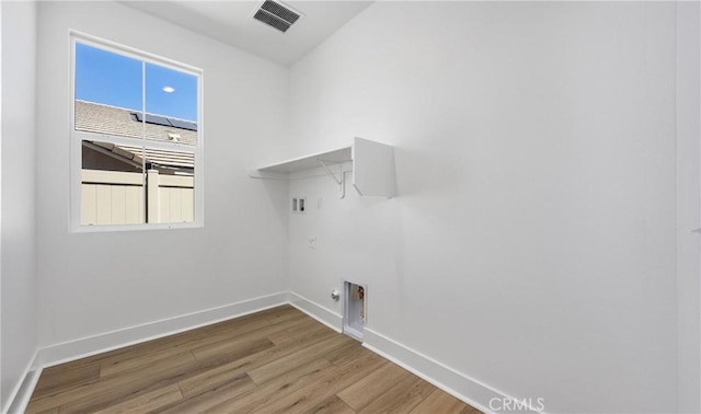 washroom featuring wood finished floors, baseboards, hookup for a washing machine, and plenty of natural light