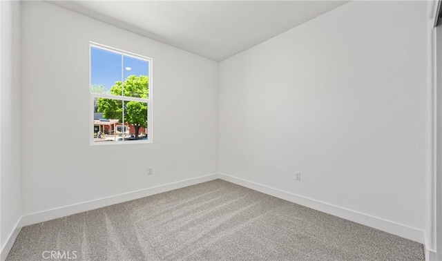 empty room with carpet and baseboards