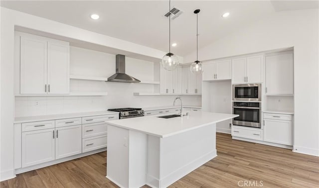 kitchen with stainless steel appliances, open shelves, a sink, wall chimney range hood, and white cabinets